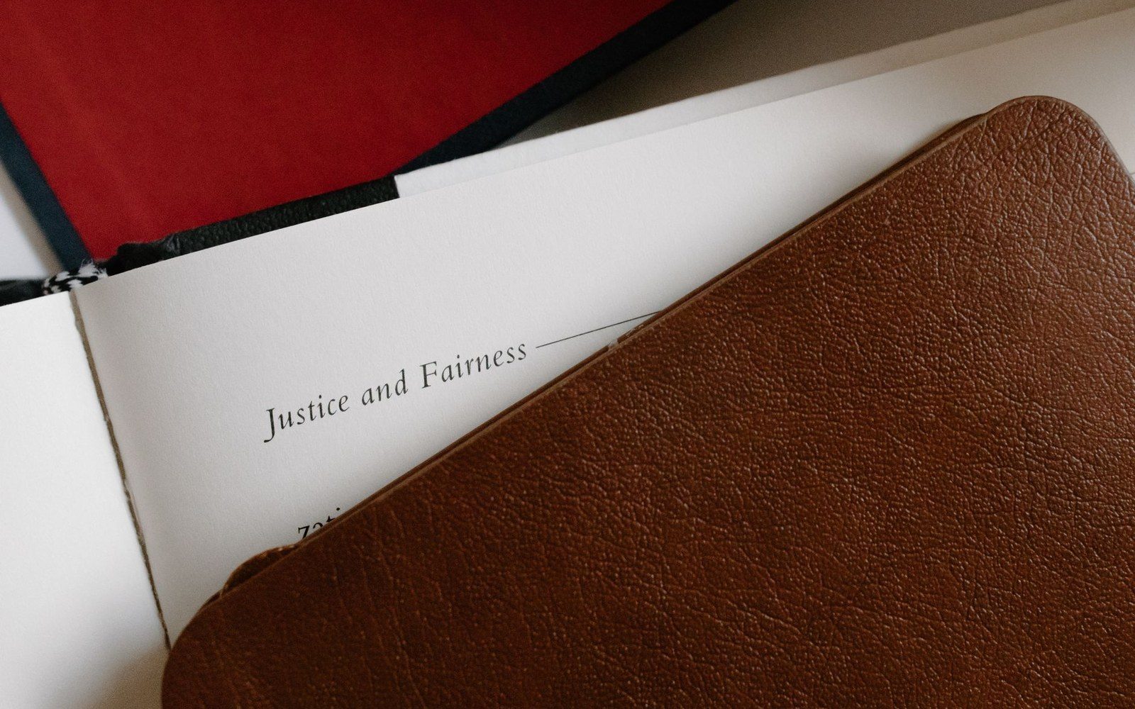 Open book page reading "Justice and Fairness" beneath a brown leather cover